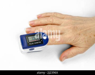 Messung der Sättigung bei einer 60-jährigen Frau. Gesundheitsfürsorge für ältere Menschen. Pulsoximeter am Finger einer älteren Frau Stockfoto