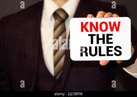 KENNE DIE REGELN, die Botschaft auf der Karte, die von einem Mann gezeigt wird. Stockfoto