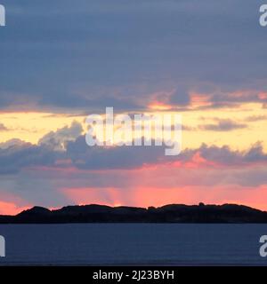 Farbfoto der letzten Glut des Sonnenuntergangs, aufgenommen von Traeth Crigyll in Rhoseigr an der Westküste auf der Isle of Anglesey, North Wales, Großbritannien, Autum Stockfoto