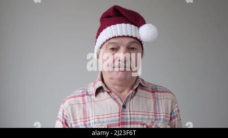 Reifer hispanischer trauriger Mann im weihnachtshut posiert im Studio Stockfoto