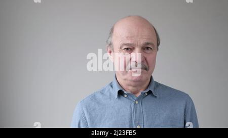 Älterer hispanischer Vater, der unzufrieden und müde aussah und von den Handlungen seiner Kinder enttäuscht wurde. Studio-Video Stockfoto