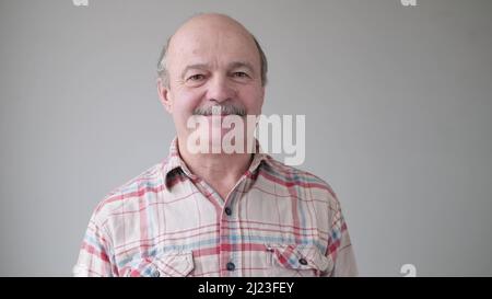 Lächelnder, reifer, lockerer hispanischer Mann mit Brille und Blick auf die Kamera. Studio-Video Stockfoto