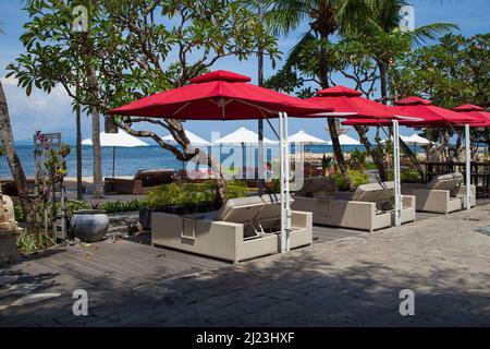 Sonnenliegen, Tische, Stühle am Strand im Griya Santrian Hotel in Sanur, Bali, Indonesien. Stockfoto