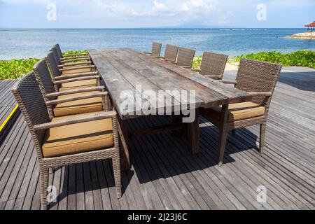 Sonnenliegen, Tische, Stühle am Strand im Griya Santrian Hotel in Sanur, Bali, Indonesien. Stockfoto