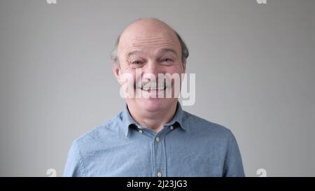 Lächelnder reifer lockerer hispanischer Mann, der die Kamera anschaut. Studio-Video Stockfoto