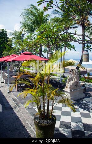 Sonnenliegen, Tische, Stühle am Strand im Griya Santrian Hotel in Sanur, Bali, Indonesien. Stockfoto