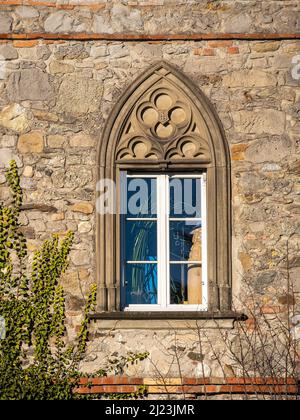 Zug, Schweiz - 31. Dezember 2021: Nahaufnahme eines weißen Fensters mit Balken in der alten Fassade mit Steinen, Stockfoto