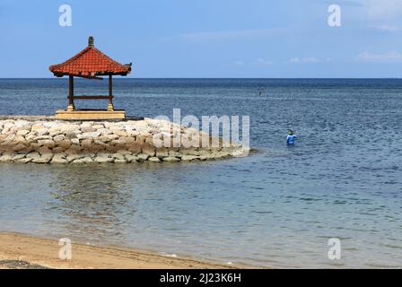 Tempel auf einem Wellenbrecher im Meer bei Sanur in Bali, Indonesien. Stockfoto