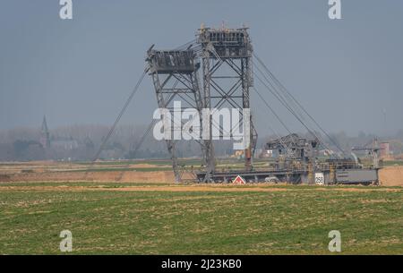 Lützerath, Deutschland, 27.03.2022, Großbagger im Braunkohlenbergwerk Garzweiler und die Keyenberg-Kirche in der Ferne, die als Demo bezeichnet wird Stockfoto