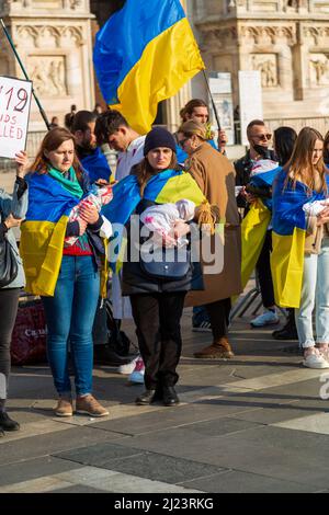 Eine vertikale Aufnahme von Müttern mit Babys in der Protestkundgebung gegen den Krieg in der Ukraine in Mailand, Italien Stockfoto