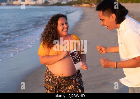 Das Schwangerenpaar hält die Ultraschalluntersuchung des Babys in der Hand. Glückliche Schwangerschaft der Familie, Erwartung. Schwarzweiß-Fotoscan Stockfoto