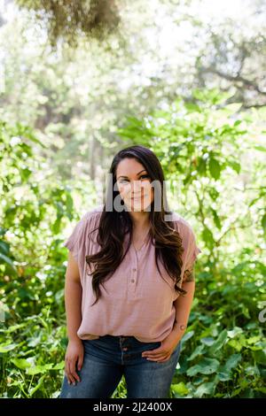 Mitte der 30er Jahre posiert eine mexikanische Frau, umgeben von Laub in San Diego Stockfoto