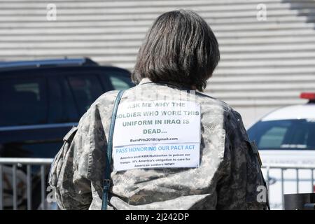 Washington, Usa. 29. März 2022. Eine Frau zeigt während einer Pressekonferenz im Senate Swamp/Capitol Hill in Washington DC ein Schild auf ihrem Rücken über die Burn Pits Gesetzgebung. Kredit: SOPA Images Limited/Alamy Live Nachrichten Stockfoto