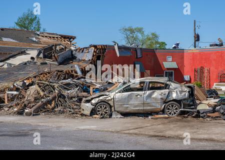 ARABI, LA, USA - 26. MÄRZ 2022: Trümmerhaufen und schwer beschädigtes Auto in der Nähe eines unbeschädigten Geschäfts auf der Friscoville Avenue, nachdem der Tornado niedergeschlagen war Stockfoto