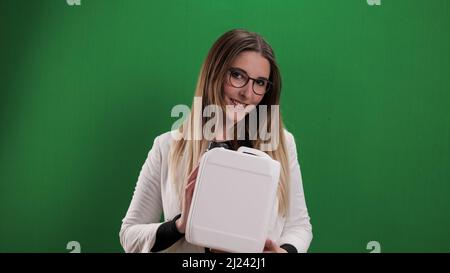 Die junge Frau hält einen Behälter – ideal für Mock-Up Stockfoto