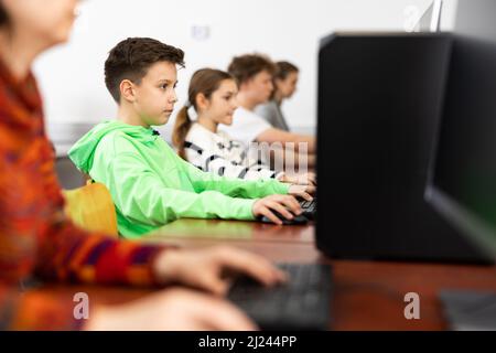 Interessiert preteen Schuljunge während Lektion in Computer-Klasse Stockfoto