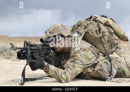 Ein Soldat, der der C-Truppe zugewiesen wurde, 3. Squadron, 61. Kavallerieregiment, 2. Stryker Brigade, 4. Infanteriedivision, Bietet Sicherheit für ihre Bildung, während sie während des Betriebs Steel Eagle in Fort Carson, Colorado, zu einem Beobachtungsposten bewegt wird, 29. März 2022. Die Operation Steel Eagle ist eine Brigade-weite Übung, die zur Integration von Manövrierkräften, Artillerieböden und der Sammlung von Informationen entwickelt wurde. Foto der US-Armee von Maj. Jason Elmore. Stockfoto