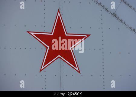 Nahaufnahme des Symbols der Sowjetunion oder des russischen roten Sterns, das auf der Metalloberfläche mit alten Militärflugzeugen gemalt ist Stockfoto