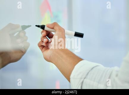 Erstellung seines Masterplans. Ausgeschnittene Aufnahme eines nicht erkennbaren Geschäftsmanns, der in seinem Büro an einem Glaswischbrett arbeitet. Stockfoto