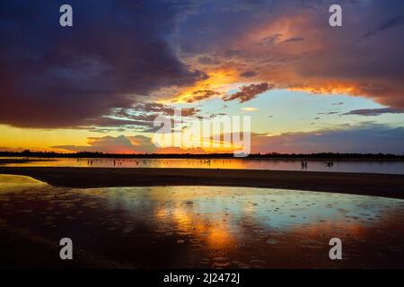 Das Ende eines heißen Tages in Summers im äußersten Nordwesten Victorias, mit Regentropfen, die in einen Salzsee fallen, und dramatischem Sonnenuntergang als Hintergrund. Stockfoto