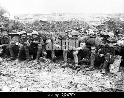 Soldaten der Canadian Expeditionary Force, möglicherweise 25. Bataillons (Nova Scotia Gewehre) der 5. Infantry Brigade, 2. Infantry Division, die auf schlammigem Boden vor einem Tierheim in der Nähe von Pozieres sitzen, während der letzten Etappe der Schlacht an der Somme, am 1916. Oktober, Möglicherweise während der Schlacht von Le Transloy. Stockfoto