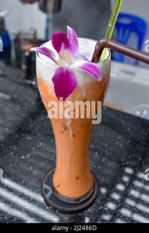Thai-Eistee mit Orchideengarnitur Stockfoto