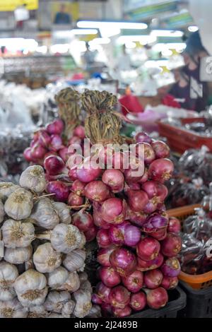 Rote Zwiebeln und Knoblauch zum Verkauf auf einem thailändischen Markt Stockfoto