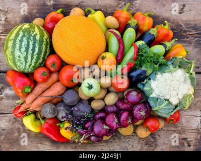 Ein Haufen buntes Gemüse auf einer hölzernen Oberfläche. Stockfoto