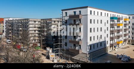 08. März 2022, Sachsen, Leipzig: Nach dem teilweisen Ausbau des Gerüsts sind die Neubauten der Leipziger Wohnungs- und Baugesellschaft (LWB) in der Saalfelder Straße erstmals richtig zu sehen. Die neue Wohnanlage mit 300 Wohnungen besteht aus 18 Häusern, die in sechs Blöcken um zwei Wohnhöfe angeordnet sind. Eine Tiefgarage bietet Platz für 170 Fahrzeuge. Voraussetzung für den Einzug ist eine Bescheinigung über die Wohnberechtigung. Nach zuletzt stagnierenden Zahlen hat sich der Sozialwohnungsbestand in Sachsen etwas erholt. (Luftaufnahme mit Drohne) P Stockfoto