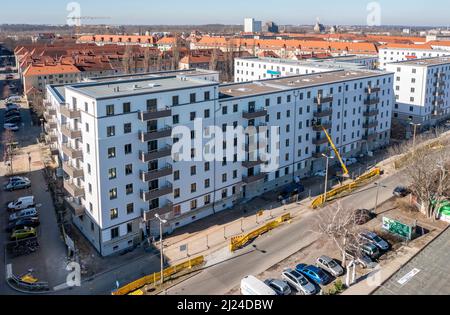 08. März 2022, Sachsen, Leipzig: Nach dem Ausbau des Gerüsts sind die Neubauten der Leipziger Wohnungs- und Baugesellschaft (LWB) in der Saalfelder Straße erstmals richtig zu sehen. Die neue Wohnanlage mit 300 Wohnungen besteht aus 18 Häusern, die in sechs Blöcken um zwei Wohnhöfe angeordnet sind. Eine Tiefgarage bietet Platz für 170 Fahrzeuge. Voraussetzung für den Einzug ist eine Bescheinigung über die Wohnberechtigung. Nach zuletzt stagnierenden Zahlen hat sich der Sozialwohnungsbestand in Sachsen etwas erholt. (Luftaufnahme mit Drohne) Foto: Stockfoto