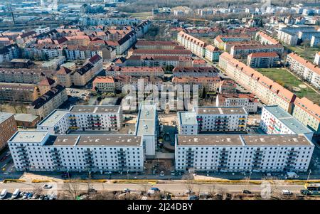 08. März 2022, Sachsen, Leipzig: Nach dem teilweisen Ausbau des Gerüsts sind die Neubauten der Leipziger Wohnungs- und Baugesellschaft (LWB) in der Saalfelder Straße erstmals richtig zu sehen. Die neue Wohnanlage mit 300 Wohnungen besteht aus 18 Häusern, die in sechs Blöcken um zwei Wohnhöfe angeordnet sind. Eine Tiefgarage bietet Platz für 170 Fahrzeuge. Voraussetzung für den Einzug ist eine Bescheinigung über die Wohnberechtigung. Nach zuletzt stagnierenden Zahlen hat sich der Sozialwohnungsbestand in Sachsen etwas erholt. (Luftaufnahme mit Drohne) P Stockfoto