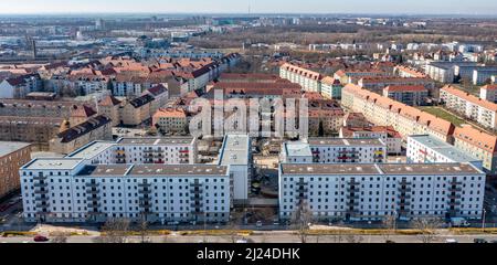 08. März 2022, Sachsen, Leipzig: Nach dem teilweisen Ausbau des Gerüsts sind die Neubauten der Leipziger Wohnungs- und Baugesellschaft (LWB) in der Saalfelder Straße erstmals richtig zu sehen. Die neue Wohnanlage mit 300 Wohnungen besteht aus 18 Häusern, die in sechs Blöcken um zwei Wohnhöfe angeordnet sind. Eine Tiefgarage bietet Platz für 170 Fahrzeuge. Voraussetzung für den Einzug ist eine Bescheinigung über die Wohnberechtigung. Nach zuletzt stagnierenden Zahlen hat sich der Sozialwohnungsbestand in Sachsen etwas erholt. (Luftaufnahme mit Drohne) P Stockfoto