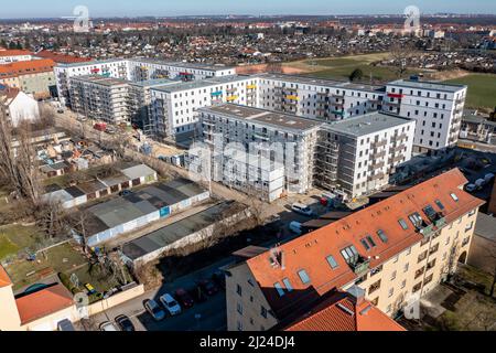 08. März 2022, Sachsen, Leipzig: Nach dem teilweisen Ausbau des Gerüsts sind die Neubauten der Leipziger Wohnungs- und Baugesellschaft (LWB) in der Saalfelder Straße erstmals richtig zu sehen. Die neue Wohnanlage mit 300 Wohnungen besteht aus 18 Häusern, die in sechs Blöcken um zwei Wohnhöfe angeordnet sind. Eine Tiefgarage bietet Platz für 170 Fahrzeuge. Voraussetzung für den Einzug ist eine Bescheinigung über die Wohnberechtigung. Nach zuletzt stagnierenden Zahlen hat sich der Sozialwohnungsbestand in Sachsen etwas erholt. (Luftaufnahme mit Drohne) P Stockfoto
