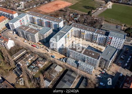 08. März 2022, Sachsen, Leipzig: Nach dem teilweisen Ausbau des Gerüsts sind die Neubauten der Leipziger Wohnungs- und Baugesellschaft (LWB) in der Saalfelder Straße erstmals richtig zu sehen. Die neue Wohnanlage mit 300 Wohnungen besteht aus 18 Häusern, die in sechs Blöcken um zwei Wohnhöfe angeordnet sind. Eine Tiefgarage bietet Platz für 170 Fahrzeuge. Voraussetzung für den Einzug ist eine Bescheinigung über die Wohnberechtigung. Nach zuletzt stagnierenden Zahlen hat sich der Sozialwohnungsbestand in Sachsen etwas erholt. (Luftaufnahme mit Drohne) P Stockfoto