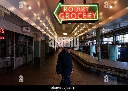 Seattle, USA. 29. März 2022. Pike Place Market nach dem Schließen, während eine Person vorbeikommt. Stockfoto