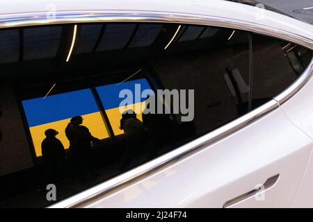 Seattle, USA. 29. März 2022. Eine Reflexion eines Tesla der Nordstom-Ukraine-Flagge. Stockfoto