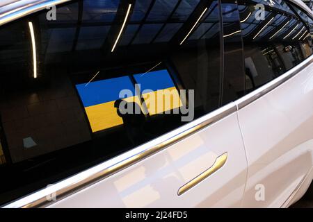 Seattle, USA. 29. März 2022. Eine Reflexion eines Tesla der Nordstom-Ukraine-Flagge. Stockfoto