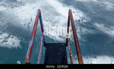 Um diese rohe Tauchplattform auf einem Teich herum sind Holzdutenspuren verstreut Stockfoto