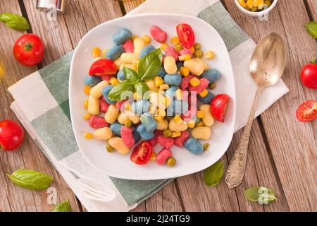 Farbige Gnocchi mit Gemüse und süßem Mais. Stockfoto