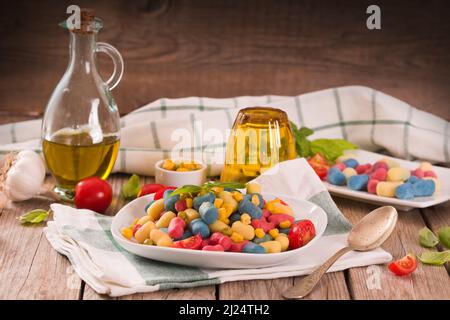 Farbige Gnocchi mit Gemüse und süßem Mais. Stockfoto