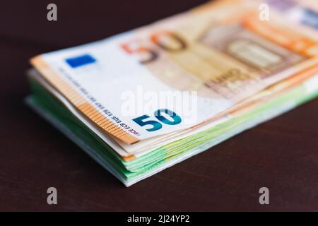 Stapel von Papier-Euro-Banknoten auf Holztisch. Haufen Geld. Selektiver Fokus. Nahaufnahme Stockfoto