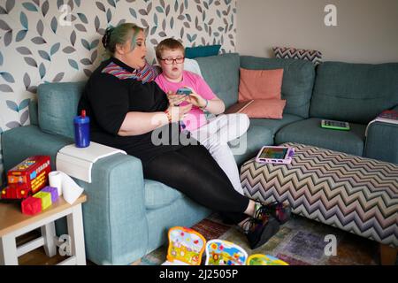 Rev. Charlotte Kephire mit ihrem Sohn Adam Kephire in ihrem Haus in Newport, Shropshire. Adam wurde mit schweren Behinderungen verlassen, nachdem das Personal sieben Stunden lang keine Antibiotika verabreichen konnte, als er während der Geburt im März 2011 eine Infektion erwischte. Der Ockenden-Bericht hat sich mit 1.862 Fällen innerhalb der Entbindungsstation in Shrewsbury und Telford NHS Trust beschäftigt, wobei die meisten Vorfälle zwischen 2000 und 2019 stattgefunden haben. Bilddatum: Dienstag, 29. März 2022. Stockfoto