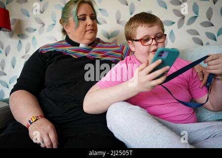 Rev. Charlotte Kephire mit ihrem Sohn Adam Kephire in ihrem Haus in Newport, Shropshire. Adam wurde mit schweren Behinderungen verlassen, nachdem das Personal sieben Stunden lang keine Antibiotika verabreichen konnte, als er während der Geburt im März 2011 eine Infektion erwischte. Der Ockenden-Bericht hat sich mit 1.862 Fällen innerhalb der Entbindungsstation in Shrewsbury und Telford NHS Trust beschäftigt, wobei die meisten Vorfälle zwischen 2000 und 2019 stattgefunden haben. Bilddatum: Dienstag, 29. März 2022. Stockfoto