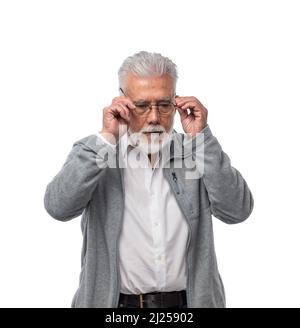 Ein älterer stilvoller Mann mit Brille mit Bart und grauem Haar sieht zur Seite und hält die Brille mit den Händen. Auf einem weißen, isolierten Hintergrund. Stockfoto