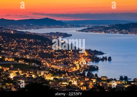 Blick in der Abenddämmerung von Feusisberg über den Zürichsee nach Zürich, mit den beleuchteten Dörfern Wollerau, Richterswil, Wawdenswil und Meilen und dem Uetliberg im Hintergrund, Kanton Zürich, Schweiz Stockfoto