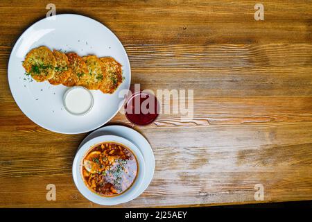 Stücke von Chop (Schnitzel), Toast mit Eiern, frischen Tomaten auf einem Holzbrett auf einem dunklen Hintergrund. Ansicht von oben. Stockfoto