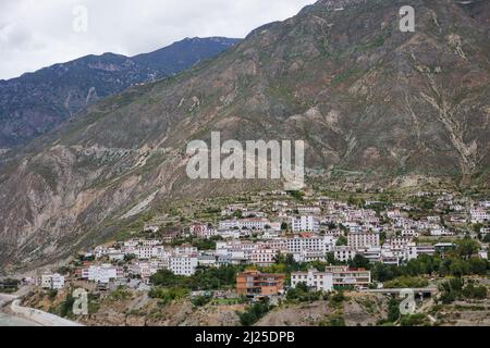 Traditionelle tibetische Stadt auf einer Hügellandschaft in der Provinz Yunnan Stockfoto