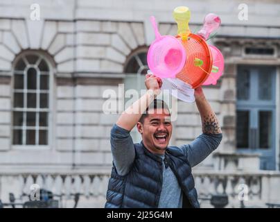 London UK 30 March 2022 der philippinische Künstler Leeroy New, mit seinem Helm aus recycelten Gegenständen, der noch bis zum 26. April anlässlich des Earth Day zu sehen sein wird. Es handelt sich um die erste britische Installation von New, die in Form von drei fantastischen, hochgedrehten Schiffen, die aus Plastikabfällen und recycelten Materialien gebaut wurden, in einem Höhenmeter vom Boden entfernt entsteht. Die Installation greift die Kultur und Mythologien der Heimat des Künstlers auf den Philippinen auf, einem Land an der vordersten Front der Klimanotlage. Paul Quezada-Neiman/Alamy Live News Stockfoto