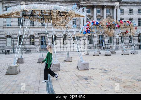London UK 30 March 2022 Somerset House präsentiert die Arks of Gimokudan des brillanten philippinischen Künstlers Leeroy New, die noch bis zum 26. April anlässlich des Earth Day zu sehen sein wird. Es handelt sich um die erste britische Installation von New, die in Form von drei fantastischen, hochgedrehten Schiffen, die aus Plastikabfällen und recycelten Materialien gebaut wurden, in einem Höhenmeter vom Boden entfernt entsteht. Die Installation greift die Kultur und Mythologien der Heimat des Künstlers auf den Philippinen auf, einem Land an der vordersten Front der Klimanotlage. Paul Quezada-Neiman/Alamy Live News Stockfoto