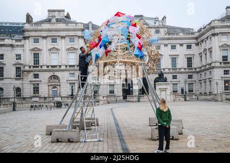 London UK 30 March 2022 der philippinische Künstler Leeroy New nimmt die letzten Anpassungen an seiner Installation vor, die noch bis zum 26. April anlässlich des Earth Day zu sehen sein wird. Es handelt sich um die erste britische Installation von New, die in Form von drei fantastischen, hochgedrehten Schiffen, die aus Plastikabfällen und recycelten Materialien gebaut wurden, in einem Höhenmeter vom Boden entfernt entsteht. Die Installation greift die Kultur und Mythologien der Heimat des Künstlers auf den Philippinen auf, einem Land an der vordersten Front der Klimanotlage. Paul Quezada-Neiman/Alamy Live News Stockfoto